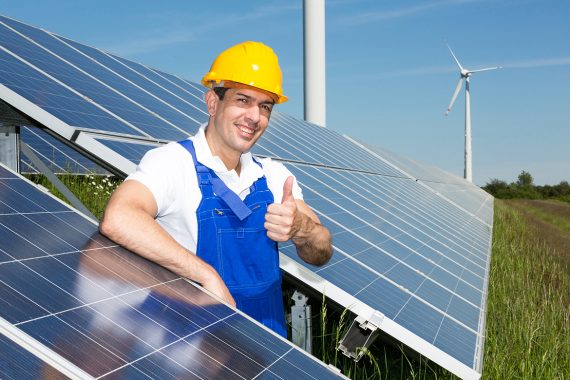 Photovoltaik-Ingenieur zeigt Daumen nach oben auf die Solarzellenanlage